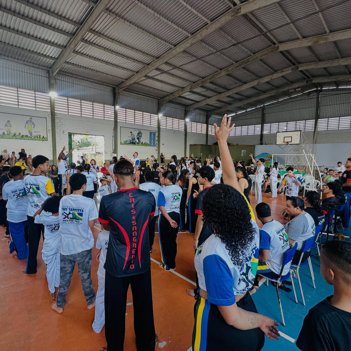 Ginásio cheio de capoeiristas durante encontro e troca de graduação